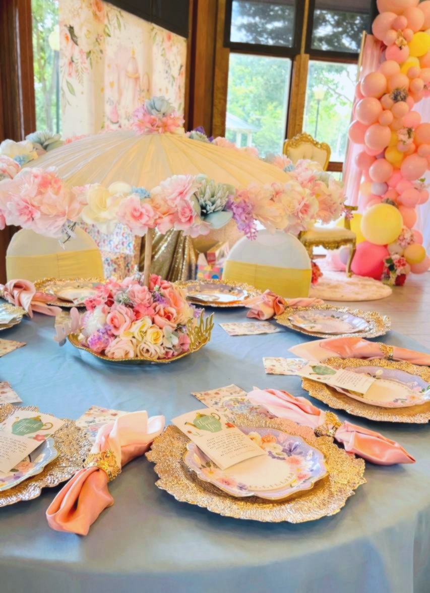Elegant pastel tea party baby shower tablescape with umbrella centerpiece and gold charger plates at Carissa Venue