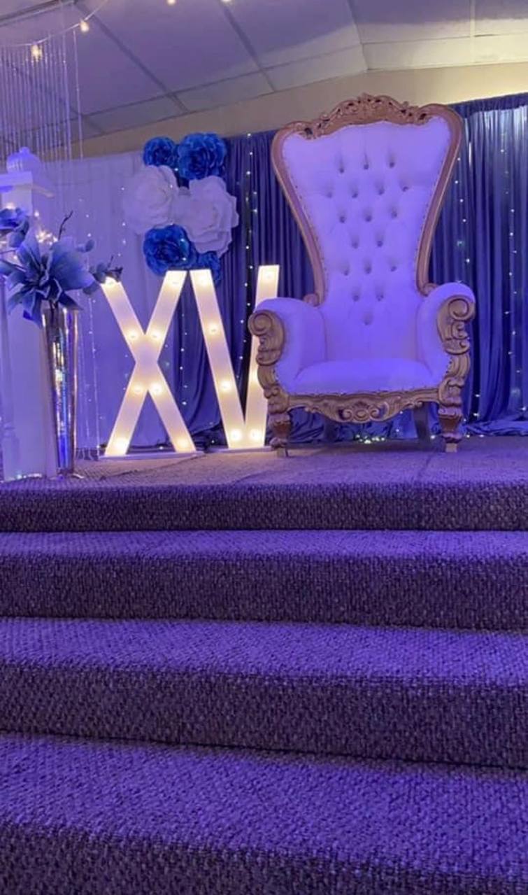 Purple XV stage with royal gold throne and illuminated marquee letters at Carissa Venue